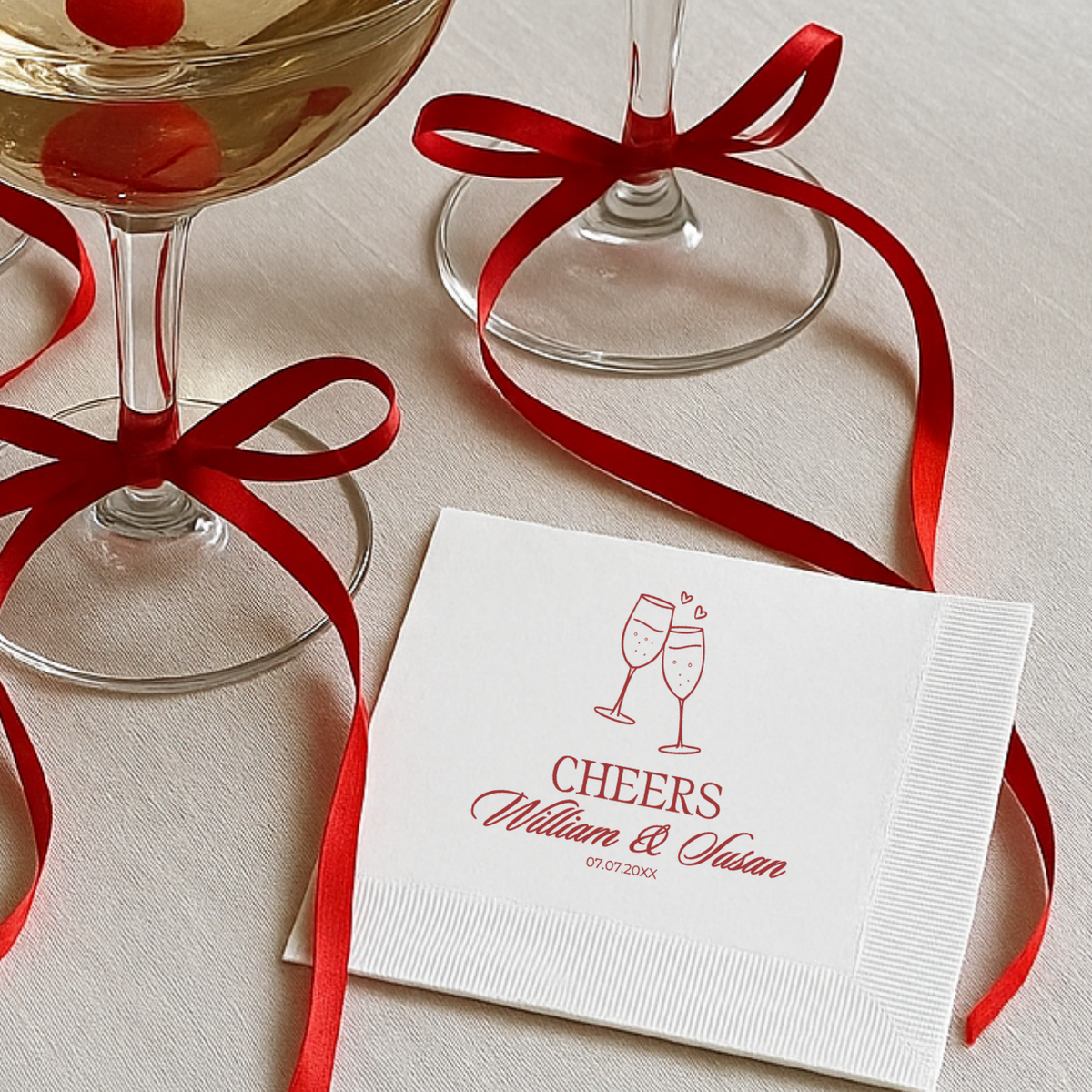 Wedding napkin with Cheers above two sparkling champagne flutes