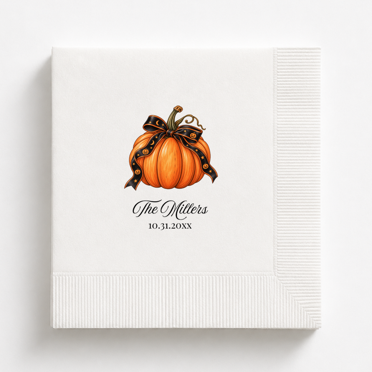 Pumpkin Halloween napkins with a black star and moon ribbon tied around the stem