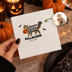 Close-up of the cat in a skeleton costume carrying a pumpkin pail on personalized cat halloween napkins