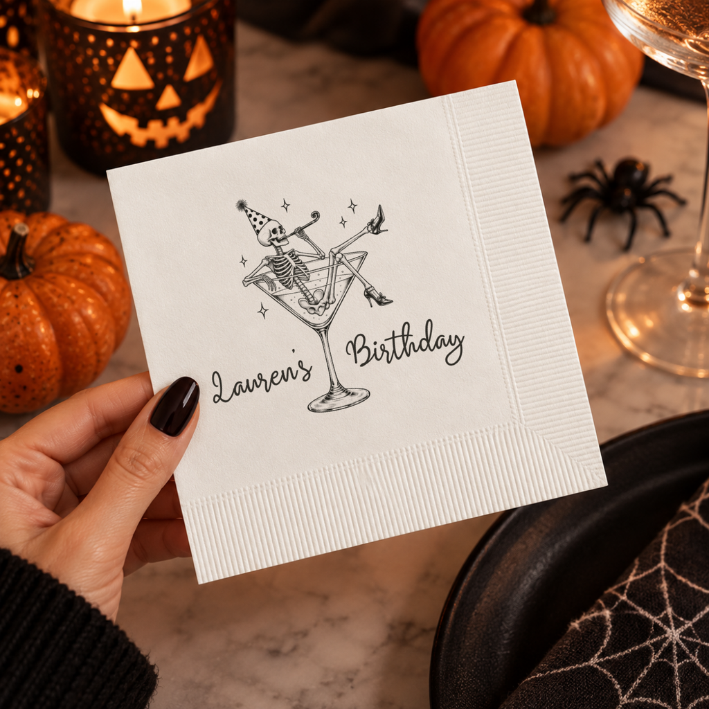 Close-up of the party skeleton lounging in a martini glass on personalized Halloween birthday napkins